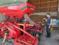 Person steht neben landwirtschaftlichem Gerät