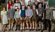 Ein Klassenfoto der Studierenden in Tracht auf einer Treppe.